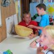Children examine a Senegalese bowl made from dried fruit